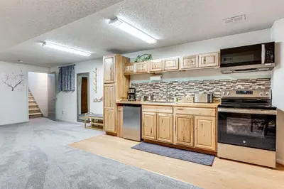 a large kitchen with wooden cabinets and appliances at Cozy Boulder Basement Unit Upscale Outdoor Space! in Boulder