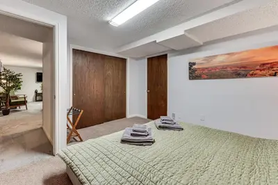 a bedroom with a bed and a painting on the wall at Cozy Boulder Basement Unit Upscale Outdoor Space! in Boulder