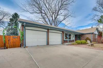 a house with two garage doors on a driveway at Cozy Boulder Basement Unit Upscale Outdoor Space! in Boulder