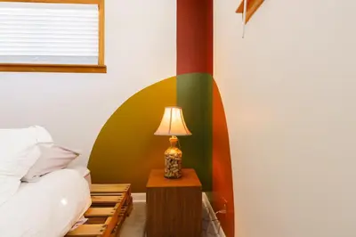 a bedroom with a bed and a lamp on a table at Retro 70s Styled Home 15 min to Downtown in Denver