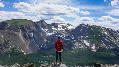 a man standing on top of a mountain at Retro 70s Styled Home 15 min to Downtown in Denver