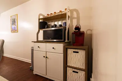 a kitchen with a microwave and a cabinet with a tv at Retro 70s Styled Home 15 min to Downtown in Denver
