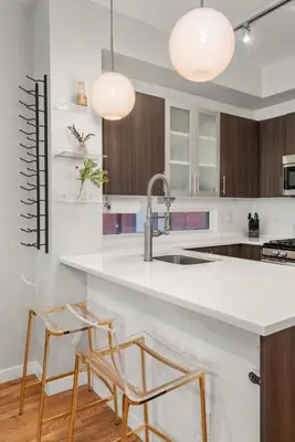 a kitchen with a sink and two chairs at a counter at Walkable Rooftop Retreat 2BR, Workspace & BBQ in Denver