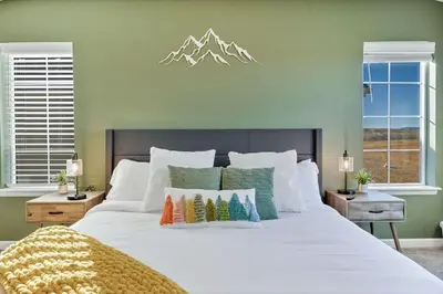 a bedroom with a large white bed with pillows at Family Friendly 5BR Mountain Views & Game Room in Superior