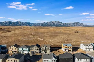 a group of houses in a field with mountains in the background at Family Friendly 5BR Mountain Views & Game Room in Superior