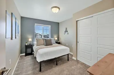 a bedroom with a white bed and a door at Family Friendly 5BR Mountain Views & Game Room in Superior