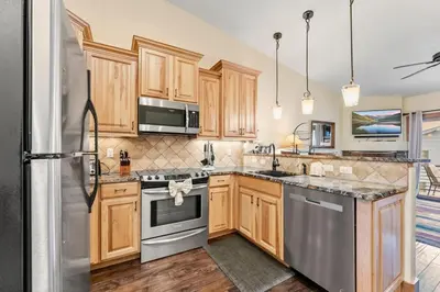 a kitchen with wooden cabinets and stainless steel appliances at 508 Ravenwood A-3 in Grand Lake