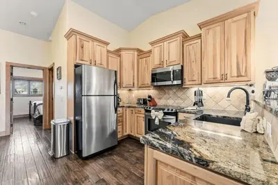 a kitchen with wooden cabinets and a stainless steel refrigerator at 508 Ravenwood A-3 in Grand Lake