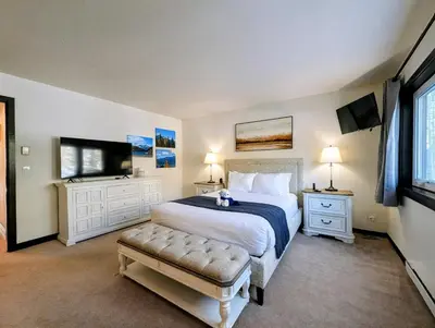 a bedroom with a large bed and a flat screen tv at Quicksilver 1674 by SummitCove Lodging in Keystone