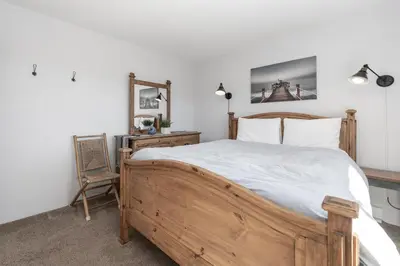 a bedroom with a wooden bed and a chair at Soda Springs Ranch Unit 3C in Grand Lake