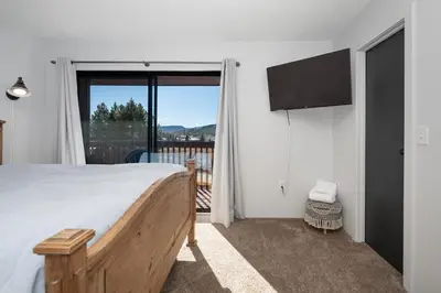 a bedroom with a bed and a television and a balcony at Soda Springs Ranch Unit 3C in Grand Lake