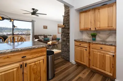 a kitchen with wooden cabinets and a living room at Soda Springs Ranch Unit 3C in Grand Lake