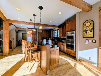 a kitchen with wooden cabinets and a island with bar stools at Keystone Retreat 33 by SummitCove Lodging in Keystone