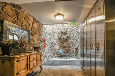 a bathroom with a stone wall at Chateaux DuMont 2710 by SummitCove Lodging in Keystone
