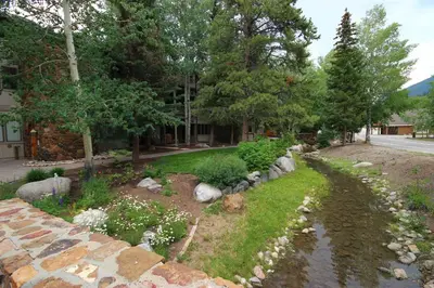 a garden with rocks and flowers in a yard at Chateaux DuMont 2710 by SummitCove Lodging in Keystone