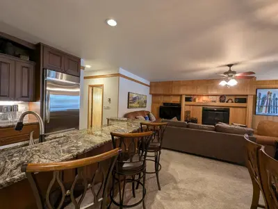 a kitchen and living room with a bar and a couch at Chateaux DuMont 2710 by SummitCove Lodging in Keystone