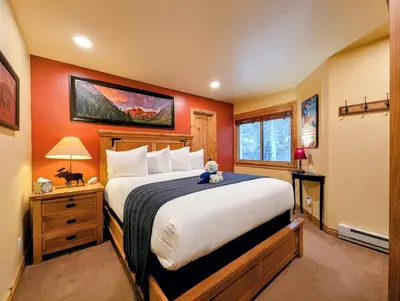 a bedroom with a large bed with a teddy bear sitting on it at Flying Dutchman 1132 by SummitCove Lodging in Keystone