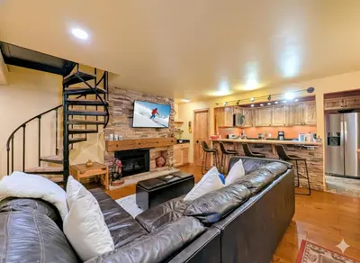 a living room with a leather couch and a fireplace at Flying Dutchman 1132 by SummitCove Lodging in Keystone