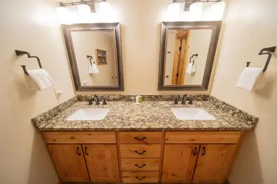 a bathroom with two sinks and two mirrors at Quicksilver 1609 by SummitCove Lodging in Keystone