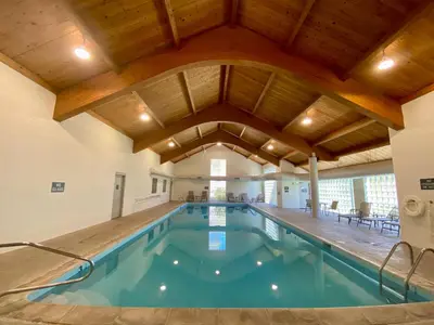 an indoor swimming pool with a large wooden ceiling at Quicksilver 1609 by SummitCove Lodging in Keystone