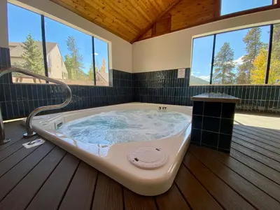 a large bath tub in a room with windows at Quicksilver 1609 by SummitCove Lodging in Keystone