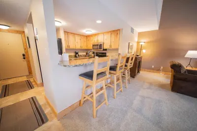 a kitchen with a table and chairs in a room at Quicksilver 1609 by SummitCove Lodging in Keystone
