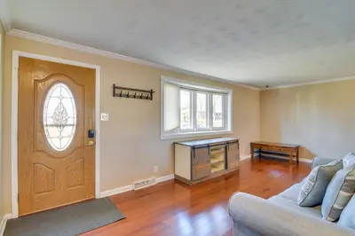 a living room with a wooden door and a couch at 2 Mi to Olde Town! Pet-Friendly Haven with Sunroom in Arvada