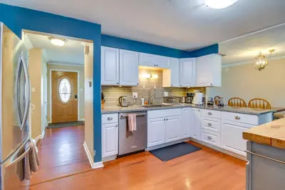 a kitchen with white cabinets and blue walls at 2 Mi to Olde Town! Pet-Friendly Haven with Sunroom in Arvada