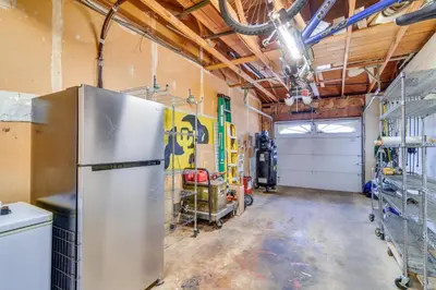 a kitchen with a refrigerator in a garage at 2 Mi to Olde Town! Pet-Friendly Haven with Sunroom in Arvada