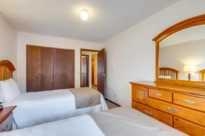 a bedroom with two beds and a dresser and a mirror at Heated Pool Access at Winter Park Base Camp! in Winter Park