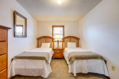 two beds in a small room with two windows at Walk to Main St! Ultimate Winter Park Getaway in Winter Park