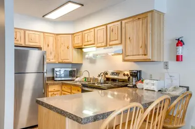 a kitchen with wooden cabinets and a stainless steel refrigerator at Heated Pool and Hot Tub! Winter Park Mtn Retreat in Winter Park