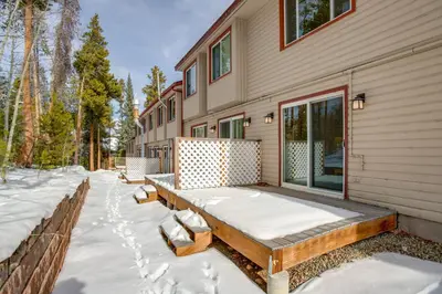 a house covered in snow next to a fence at Heated Pool and Hot Tub! Winter Park Mtn Retreat in Winter Park