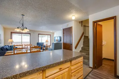 a kitchen and living room with a counter and a dining room at Pool and Hot Tub! Hub for All-Season Winter Park Fun in Winter Park