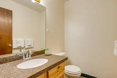 a bathroom with a sink and a toilet and a mirror at Heated Pool and Hot Tubs at Dtwn Winter Park Condo! in Winter Park