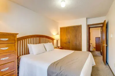 a bedroom with a large bed and a wooden dresser at Heated Pool and Hot Tubs at Dtwn Winter Park Condo! in Winter Park