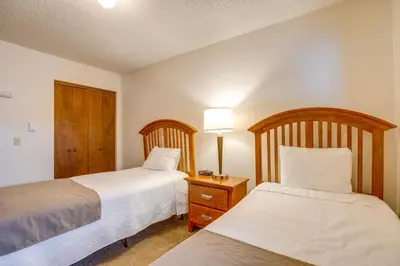 a bedroom with two beds and a nightstand with two beds at Heated Pool and Hot Tubs at Dtwn Winter Park Condo! in Winter Park