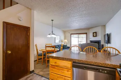 a kitchen and living room with a table and chairs at 3 Mi to Winter Park Slopes! Unit with Pool and Hot Tub in Winter Park