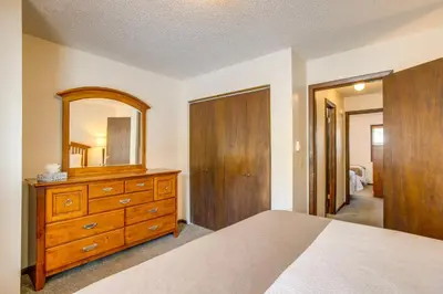 a bedroom with a bed and a dresser with a mirror at 3 Mi to Winter Park Slopes! Unit with Pool and Hot Tub in Winter Park