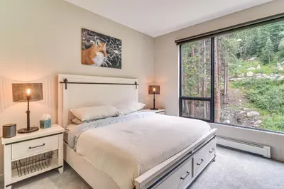 a bedroom with a bed and a large window at Ski-InandSki-Out! Winter Park Family Gem with Hot Tub in Winter Park