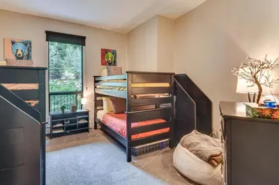 a bedroom with two bunk beds and a desk at Ski-InandSki-Out! Winter Park Family Gem with Hot Tub in Winter Park