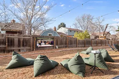 a group of pillows on the ground next to a fence at Backyard Movie, Hot Tub & 2 Game Rooms in Arvada