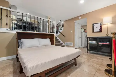a bedroom with a bed in a room with a staircase at Backyard Movie, Hot Tub & 2 Game Rooms in Arvada