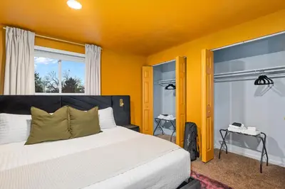 a bedroom with a large bed with yellow walls at Backyard Movie, Hot Tub & 2 Game Rooms in Arvada