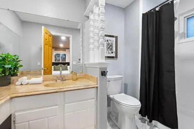 a white bathroom with a sink and a toilet at Backyard Movie, Hot Tub & 2 Game Rooms in Arvada