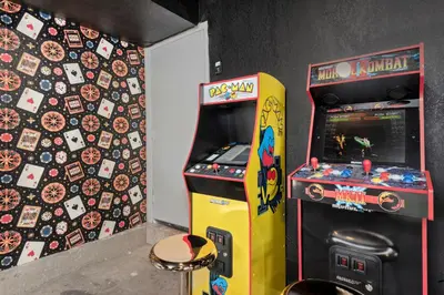 a arcade video game machine next to a pinball at Backyard Movie, Hot Tub & 2 Game Rooms in Arvada