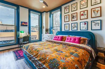 a bedroom with a bed and some pictures on the wall at Shop, Dine, Unwind! Couples Retreat in Dtwn Golden in Golden