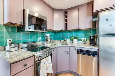 a kitchen with pink cabinets and a stainless steel refrigerator at Shop, Dine, Unwind! Couples Retreat in Dtwn Golden in Golden