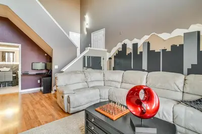 a living room with a couch and a city mural at WFH Setup and Garage Parking! Modern Denver Condo in Thornton