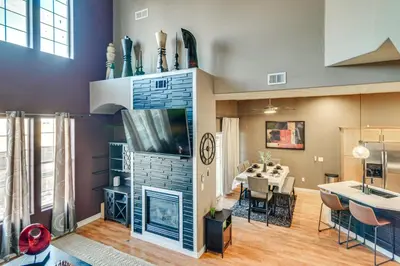 a living room with a fireplace and a tv at WFH Setup and Garage Parking! Modern Denver Condo in Thornton